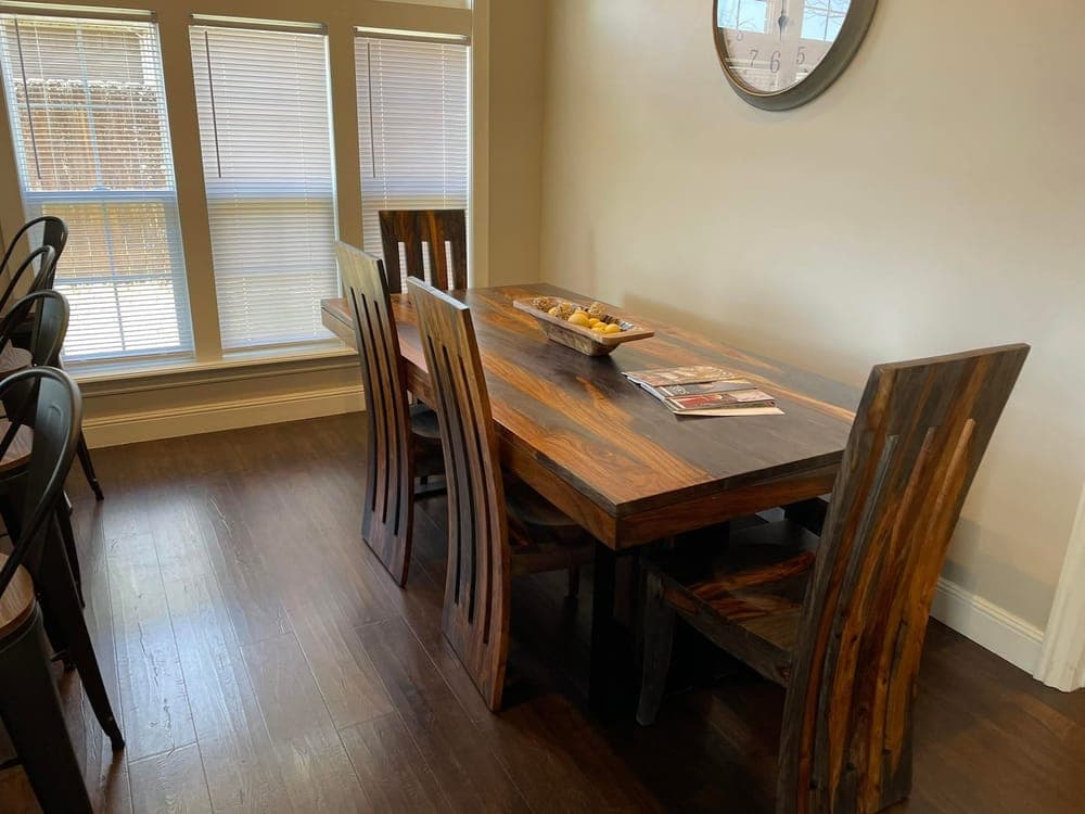 A dining room with the table cleared and the floor cleaned.