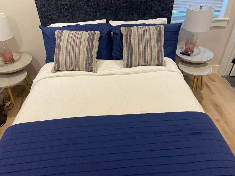 A guest bedroom staged with the bed remade for the next guest.