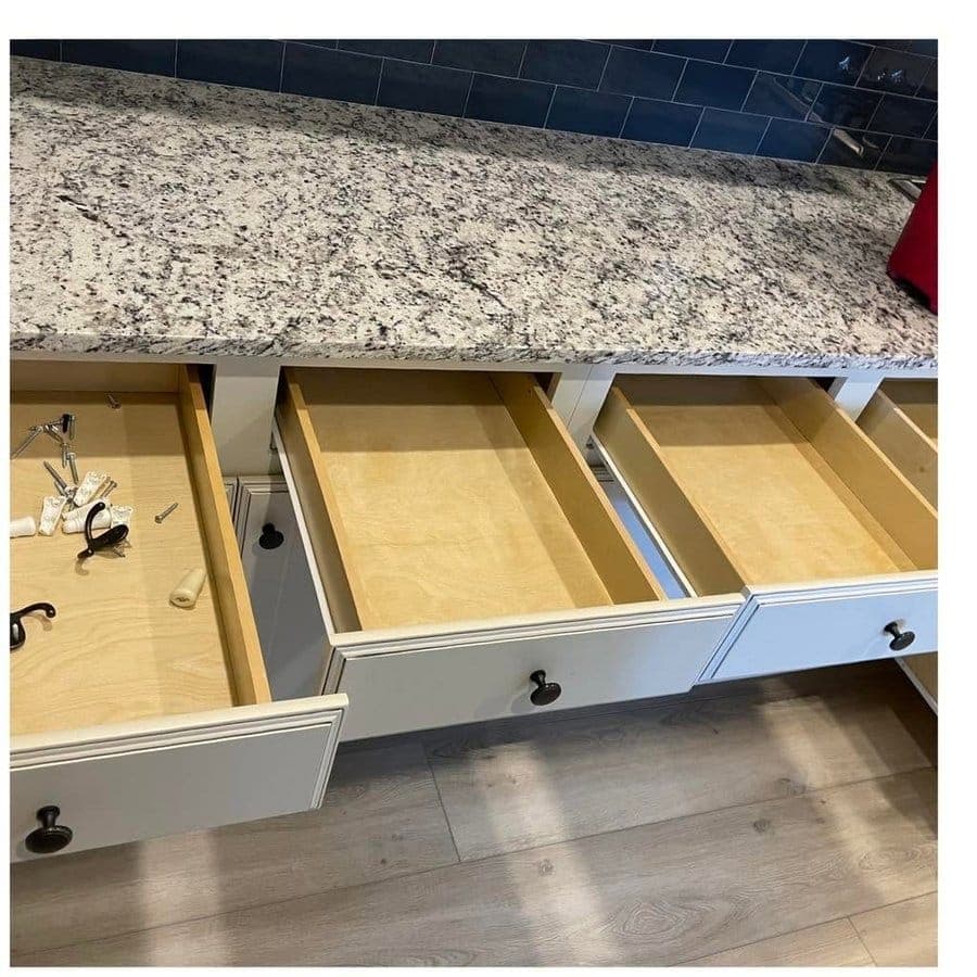 Kitchen drawers pulled fully open, emptied and wiped inside.