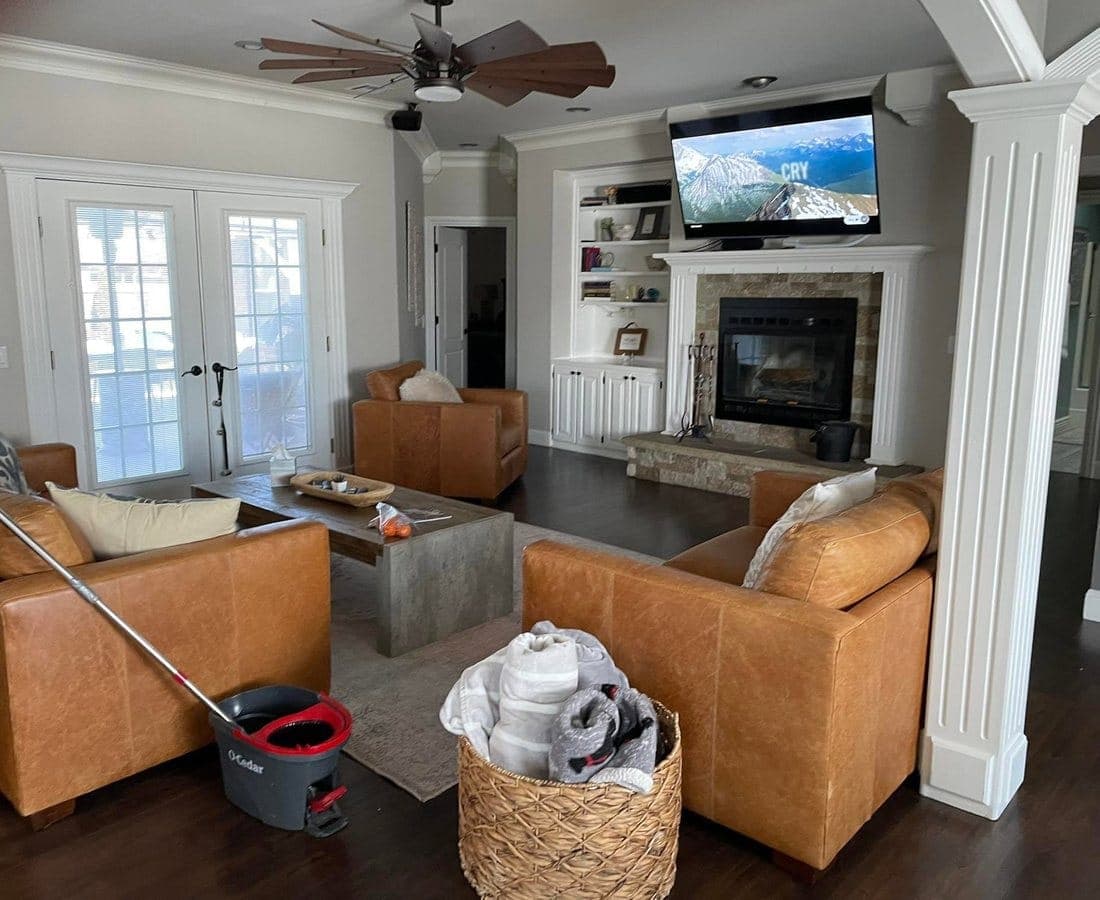 An open living room mid-clean, mop and bucket in frame.